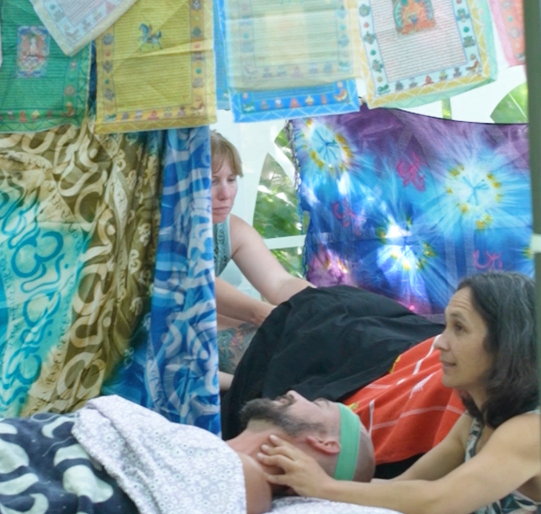 Two people interacting with colorful fabric art in a casual setting